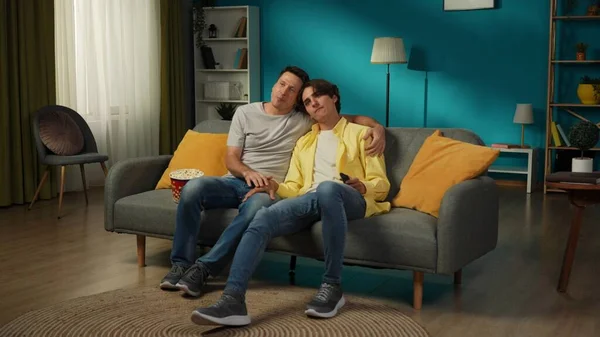 一对同性恋夫妇在家里拍的全景照片他们坐在沙发上 一起看电视 吃爆米花 彼此表达爱意 Lgbt — 图库照片