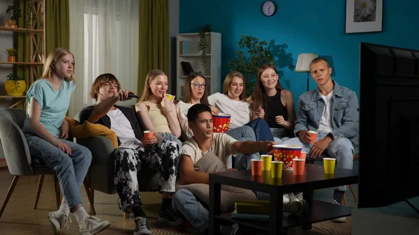 全尺寸射击 一群青少年 年轻人 坐在沙发上看电视 看电影 看节目的朋友 他们在吃爆米花 开玩笑 青少年 青年内容 — 图库照片