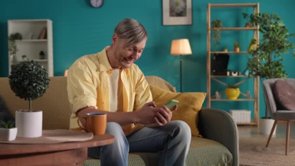 Homme Est Assis Dans Salon Sur Canapé Avec Smartphone Dans — Video