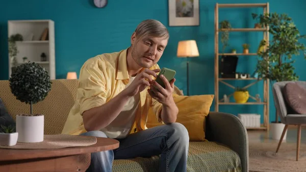 Hombre Que Usa Teléfono Inteligente Mientras Está Sentado Sofá Casa —  Fotos de Stock