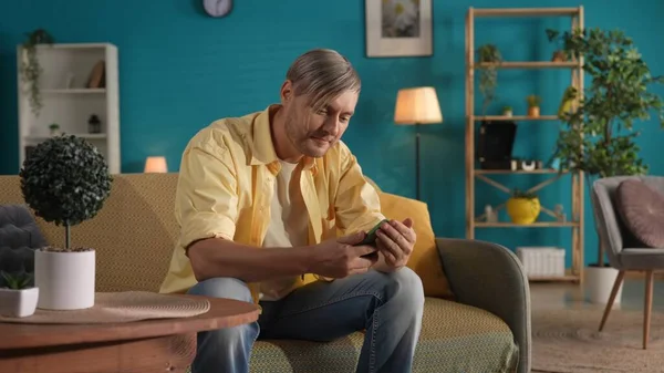 Mies Joka Käyttää Älypuhelinta Istuessaan Sohvalla Kotona Lähellä Mies Selaa — kuvapankkivalokuva