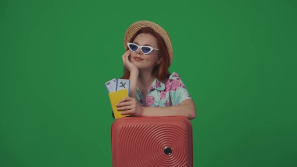 旅行広告クリエイティブコンセプト カメラで飛行券 パスポート 笑顔を持ったストローハットとグラスで美しい女性旅行者 緑の背景に孤立した — ストック動画
