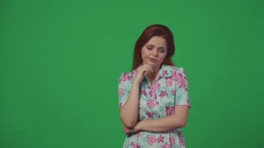 Gezici reklam yaratıcı konsepti. Kadın üzgün görünüyor, bir fikri var, çiçek çelengi ve gözlük takıyor, uçuş biletlerini alıyor, parmaklarını göstererek mutlu bir şekilde kaçıyor. Yeşil arkaplanda izole.