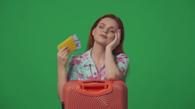 Gezici reklam yaratıcı konsepti. Elinde bavulu olan bir kadın yolcu uçuş biletleri, gülen surat ifadesi, elleri havaya kaldıran yumruklar. Yeşil arkaplanda izole.