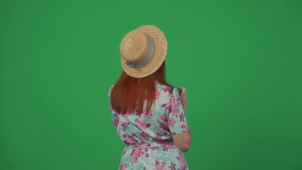 旅行广告创意的概念 头戴草帽的女旅行者拿着旧胶卷摄像头环视四周 转身看着相机 满脸诧异地拍照 被绿色背景隔离 — 图库视频影像