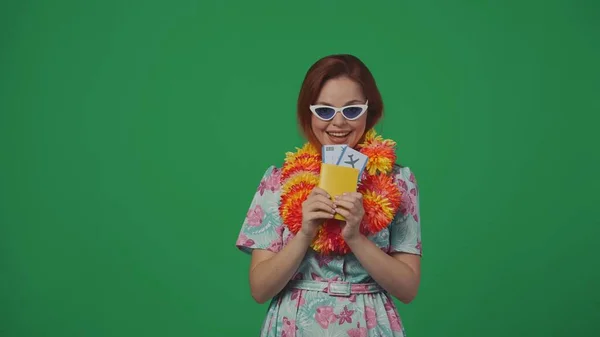 旅行广告创意的概念 穿着衣服的女旅行者站在那里 头戴花环 笑容满面 拿着飞机票 被绿色背景隔离 — 图库照片
