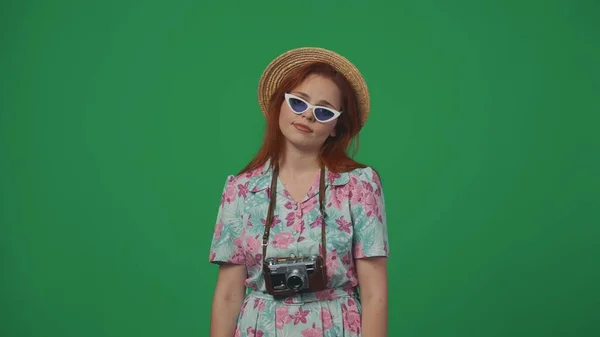 旅行広告クリエイティブコンセプト 休暇中の遠足に疲れている古いフィルムカメラでわら帽子をかぶった女性 緑の背景に孤立した — ストック写真