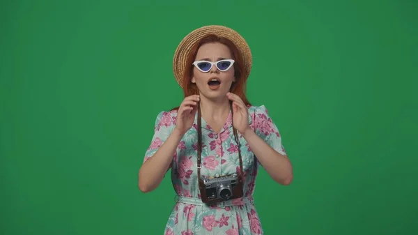 旅行广告创意的概念 女旅行者头戴草帽 戴着眼镜四处张望 手牵着嘴叫人 被绿色背景隔离 — 图库照片