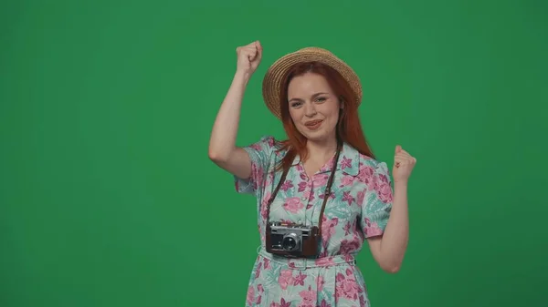旅行広告クリエイティブコンセプト ストロー帽子と古いフィルムカメラを首の上に旅行する女性は 手を握り 拳をポンピングする幸せな陽気な顔の表情で 緑の背景に孤立した — ストック写真