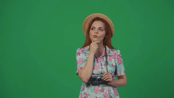 旅行広告クリエイティブコンセプト ストロー帽子の女性は フィルムカメラを保持し 焦点を当てた顔の何かを考えています 緑の背景に孤立した — ストック写真