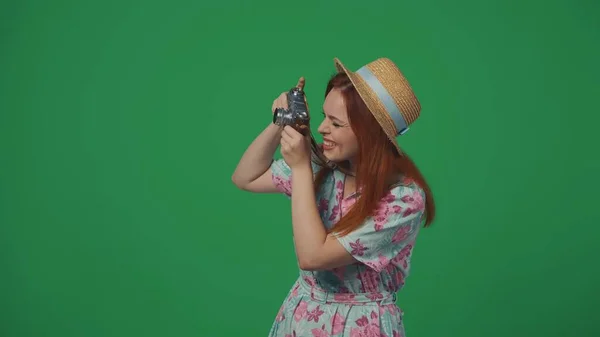 旅行広告クリエイティブコンセプト カメラから離れて 休暇中に有名な場所の写真を撮る古いフィルムでわら帽子で女性旅行者 緑の背景に孤立した — ストック写真