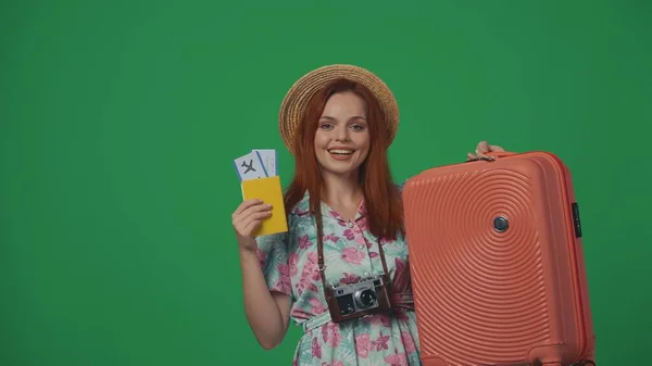 旅行广告创意的概念 头戴草帽的女旅客拿着机票 护照和手提箱 笑容满面 被绿色背景隔离 — 图库照片