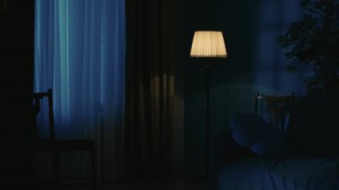 Daire yaratıcı konseptinde korku filmi sahnesi. Önünde modern mobilyalar, sandalye ve kanepe olan karanlık oturma odasının yakın çekimi, pencerenin dışında fırtına var..
