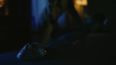 Daire yaratıcı konseptinde korku filmi sahnesi. Yakın çekim, beyaz hokey maskesine odaklan. Arkadaki adam, kurbanı bıçaklayarak öldürüyor. Maskeyi alıyor ve uzaklaşıyor..