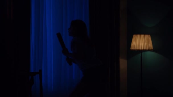 アパートのクリエイティブコンセプトのホラー映画シーン 窓の近くに野球バットが立っていて 外を見回し 緊張した雰囲気の恐ろしい少女のクローズアップショット Hdr Bt2020について — ストック動画