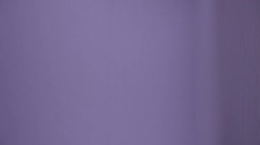 Temizlik ve temizlik yaratıcı konsepti. Günlük kıyafet ve lastik eldiven giymiş bir kadın paspas ve kovayla çerçeveye giriyor, paçavralar ve suyla, etrafına bakıyor, kameraya gülümsüyor. Dikey video.