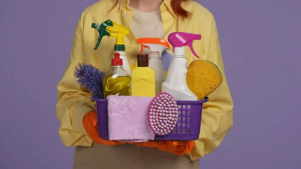 日常清洁和家务事的概念 女用橡胶手套用洗涤剂 刷子和海绵托住篮子的特写镜头 被紫色背景隔离 — 图库照片