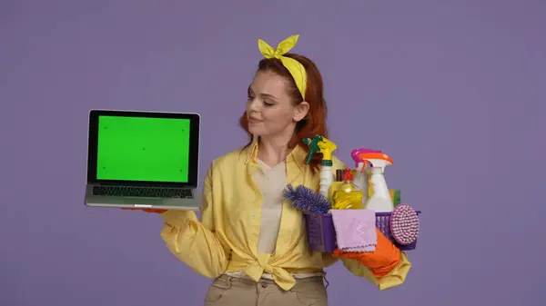 日常清洁和家务事的概念 身穿休闲装 戴着橡胶手套 手持笔记本电脑和清洁剂的女人 看着屏幕 广告区 工作空间模型 — 图库照片