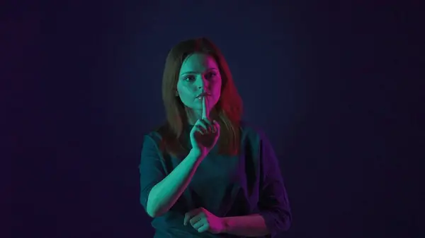 一个年轻的女人在看不见的触摸屏上工作 工作室里的一个女人 蓝色背景 粉色和绿色霓虹灯 未来主义技术 — 图库照片