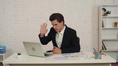 Ofiste dizüstü bilgisayarının önünde oturan genç bir adamın video görüntüsü. Konuşmaya başlıyor, biriyle konuşuyor grafikler ve grafikler gösteriyor, tartışıyor ve azarlıyor. İş, uygulama.