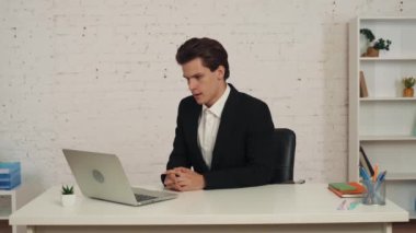 Bilgisayarının önünde oturmuş video aramasını bekleyen genç bir adamın orta boy videosu. Sonra konuşmaya başlıyor, biriyle konuşuyor, tartışıyor ve azarlıyor. İş, web kaynakları, uygulama.