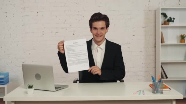 Ofisteki Masada Oturan Genç Bir Adamın Elinde Bir Kontrat Tutarken — Stok video