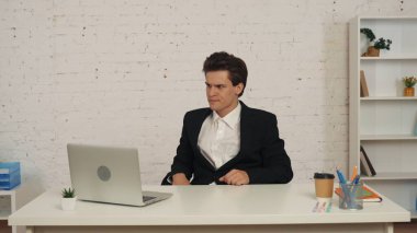 Orta ölçekli bir ofis çalışanı, ofiste masada oturan bir iş adamı endişeli, kafası karışmış bir şekilde bir şeyler düşünürken görüntüsü. İş, bayilik, reklam.