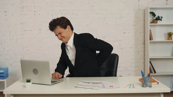 Tiro Médio Jovem Sentado Mesa Trabalhando Laptop Massageando Aquecendo Como — Fotografia de Stock