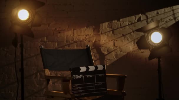 电影摄影和电影舞台为后台创意理念奠定了基础 导演椅子上的黑色拍板 后台放映机 演播室里温暖的灯光 — 图库视频影像