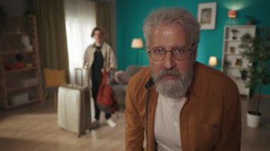 Bir gencin, büyükbabasıyla birlikte genç bir adamın, sanki fotoğraf çekiyorlarmış gibi kameraya poz veren büyükbabasının videosu. Yanlarında bir bavul var, çocuk taşınıyor, üniversiteye gidiyor..
