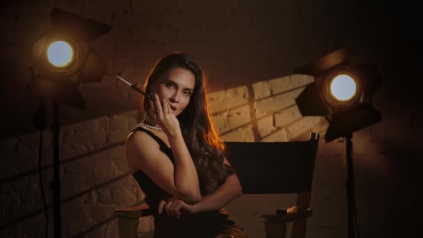 Koncepcja Reklamy Kulisami Kobieta Czarnej Sukience Siedząca Krześle Reżyserskim Trzymająca — Wideo stockowe