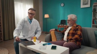 Hastanın evdeki durumunu kontrol eden bir doktorun tam boy videosu. Sağlık sorunları olan yaşlı bir adamla konuşuyor ve röntgen çektiriyor. Sağlık sistemi, sağlık hizmetleri