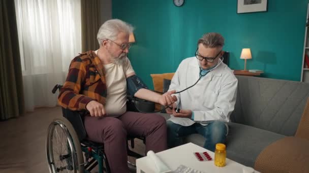 집에서 환자를 확인하는 의사의 비디오 휠체어를 노인의 혈압을 측정하기 스테로스코프와 — 비디오