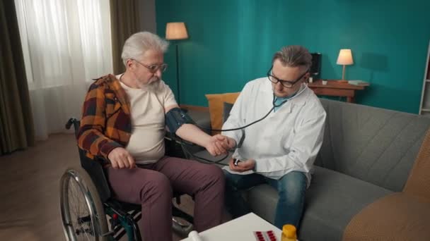 집에서 환자를 확인하는 의사의 비디오 휠체어를 노인의 혈압을 측정하기 스테로스코프와 — 비디오