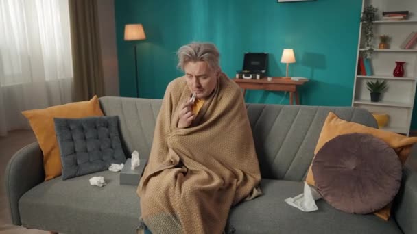 Orta Yaşlı Bir Adamın Kanepeye Oturup Battaniyeye Sarılı Bir Şekilde — Stok video