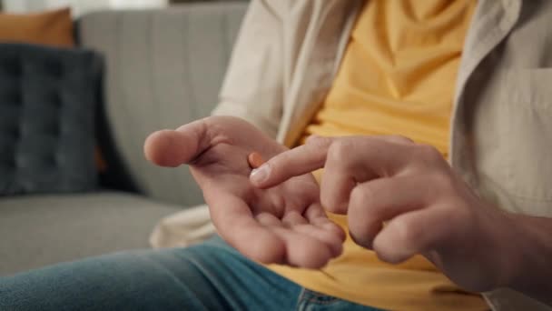 クローズアップ ソファーに座っている中年の男の手のひらの詳細なビデオ 薬を示す 彼の手に薬 指でそれらに触れる ヘルスケア 医薬品広告 — ストック動画