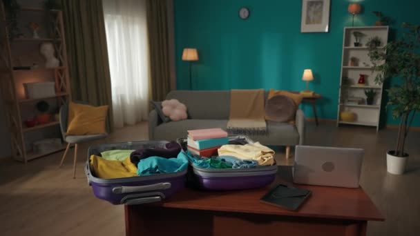 スーツケースのビデオで テーブルの上に横たわっているいくつかの持ち物と詰め込まれています 日光でいっぱいの部屋 背景に家具 アドベンチャータイム 観光広告 — ストック動画
