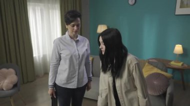 Genç bir kadının bavulunu ve sırt çantasını alıp annesine veda ettiği ve ona nazikçe sarıldığı bir video. Kız üniversiteye, üniversiteye gidiyor, başka bir yere taşınıyor. HDR