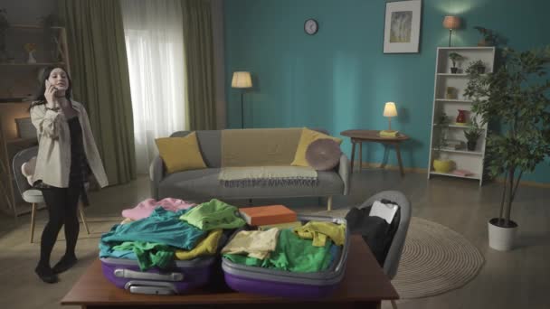 ティーンエイジャー ティーン 若い女性のビデオ 前景に横たわるスーツケースを梱包しながら 幸せなことを話し合う 新しい場所に引っ越す — ストック動画