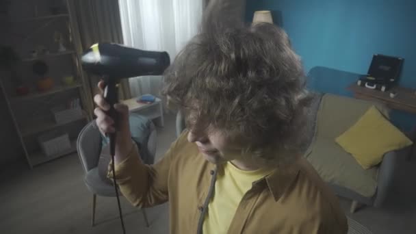 Close Young Man Standing Room Holding Hair Dryer Looks Him — Stock Video