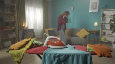 Kız video iletişimiyle coşkulu bir şekilde konuşuyor. Ütünün yanında sigara içmeye başlar. Kız, panikte ne olduğunu fark eder ve kapatmaya çalışır. Konuşmaya devam et. HDR BT2020