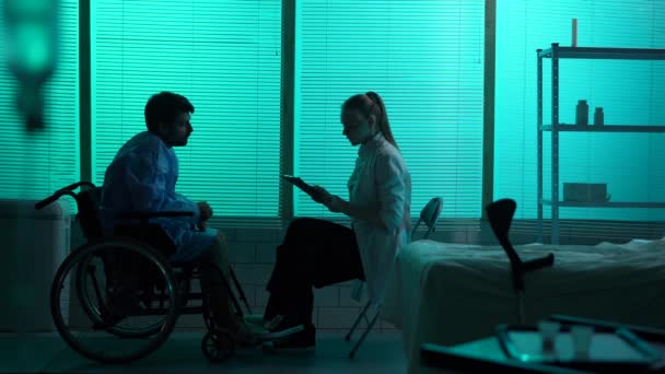 全尺寸的轮廓视频一个残疾男子 行动障碍患者在轮椅上与一位女医生交谈谁告诉了他坏消息 这个人既震惊又绝望 — 图库视频影像