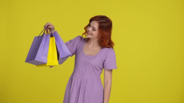 Genç Kızıl Saçlı Bir Kadın Elinde Parlak Alışveriş Torbaları Tutarak — Stok video