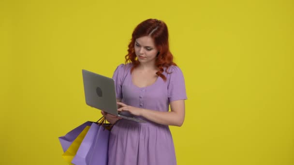 Uma Mulher Com Sacos Compras Está Usando Laptop Olhando Através — Vídeo de Stock