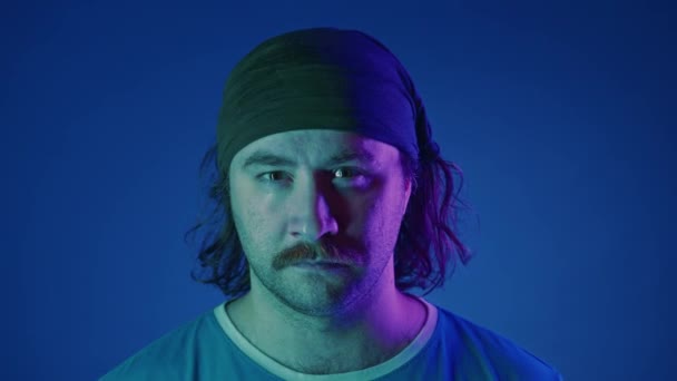 분홍색과 파란색 배경에 스튜디오에서 밴드에 Mustachioed 남자의 초상화 남자는 똑바로 — 비디오