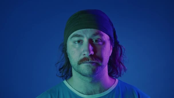 Porträtt Mustascherad Man Ett Pannband Studio Med Blå Bakgrund Rosa — Stockvideo