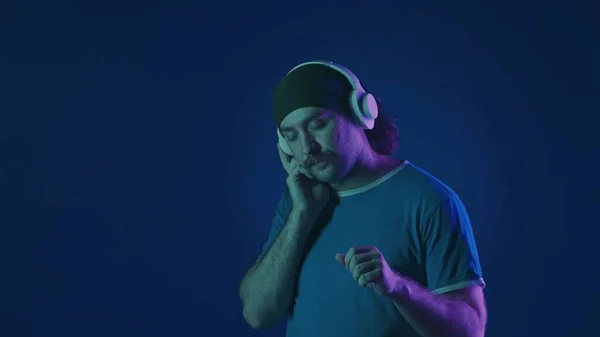 Muž Bílých Bezdrátových Sluchátkách Poslouchá Hudbu Tance Muž Ateliéru Modrém — Stock fotografie