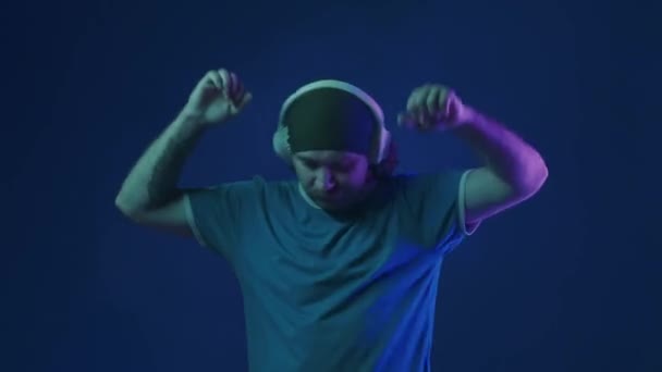 Muž Bílých Bezdrátových Sluchátkách Poslouchá Hudbu Energicky Tancuje Muž Ateliéru — Stock video