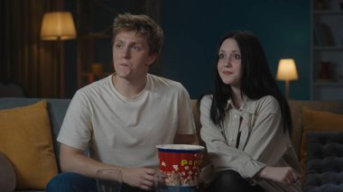 İlk ilişkiler yaratıcı konsept. Genç bir çiftin boş zamanlarını odada geçirdiği portre. Oğlan ve kız kanepede oturup patlamış mısır yiyor ve utangaç ve kafası karışmış bir şekilde film izliyorlar..