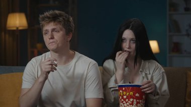 İlk ilişkiler yaratıcı konsept. Boş zamanlarını geçiren genç bir çiftin portresi. Oğlan ve kız kanepede oturur, oğlan bir sigara sarması tutar ve kıza verir, kız olumsuz görünür..